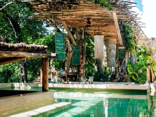 The Orquidea bar under the palapa roof, with the chalkboard menus and the pool in front