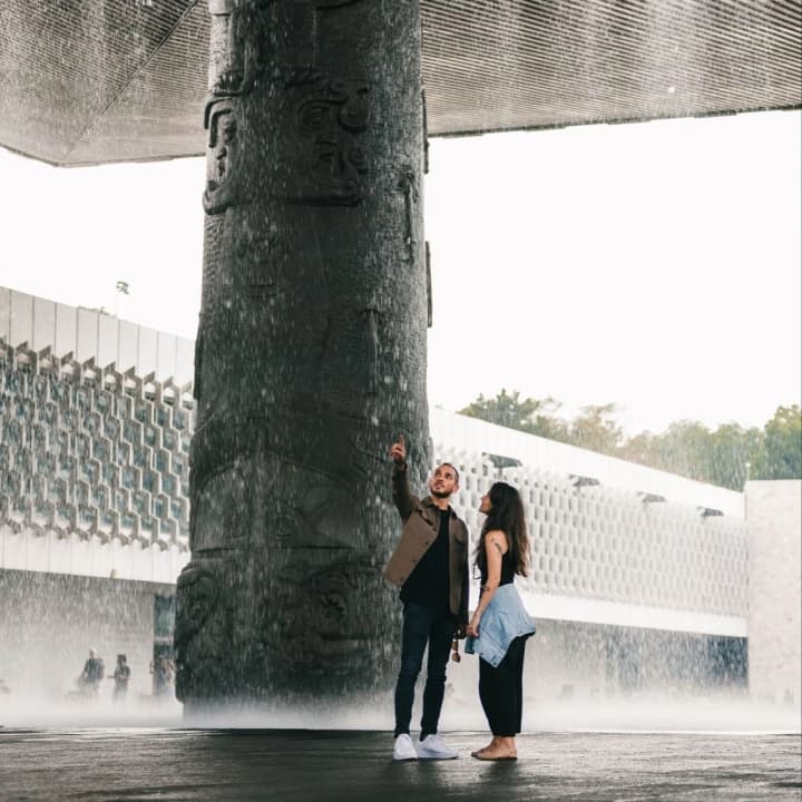 A couple under the "El Paraguas" waterfall, at the National Museum of Anthropology